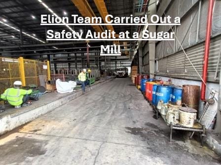 Three workers in safety gear inspect an industrial facility with barrels, equipment, and safety barriers. Text over image reads, “Elion Team Carried Out a Safety Audit at a Sugar Mill,” highlighting workplace safety measures.