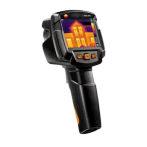 A handheld thermal imaging camera displays a heat map of a house on its screen, showing temperature variations in colors like yellow, orange, and purple.